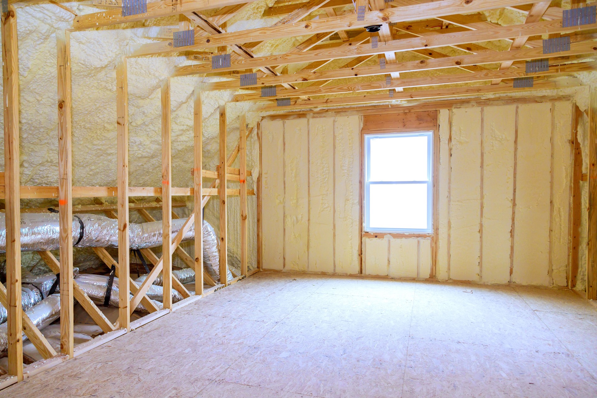 Thermal foam insulation ceiling is installed under roof of a new frame house during construction